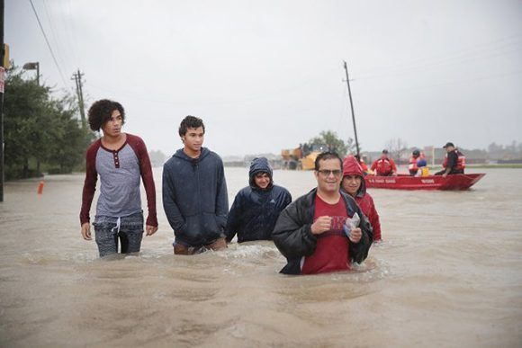 HOUSTON, TX - AUGUST 28: People make their way out of a flooded neighborhood after it was inundated with rain water, remnants of Hurricane Harvey, on August 28, 2017 in Houston, Texas. Harvey, which made landfall north of Corpus Christi late Friday evening, is expected to dump upwards to 40 inches of rain in areas of Texas over the next couple of days.   Scott Olson/Getty Images/AFP == FOR NEWSPAPERS, INTERNET, TELCOS & TELEVISION USE ONLY ==