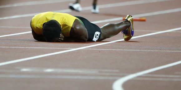 Athletics - World Athletics Championships – men’s 4 x 100 meters relay final – London Stadium, London, Britain – August 12, 2017 – Usain Bolt of Jamaica lays on the track after sustaining an injury. REUTERS/Lucy Nicholson