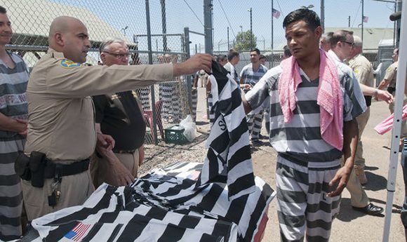 Los presos reciben un nuevo uniforme con la bandera de EEUU en un acto ante la prensa en la cárcel en julio de 2016. Foto: Gary Williams/ EFE.