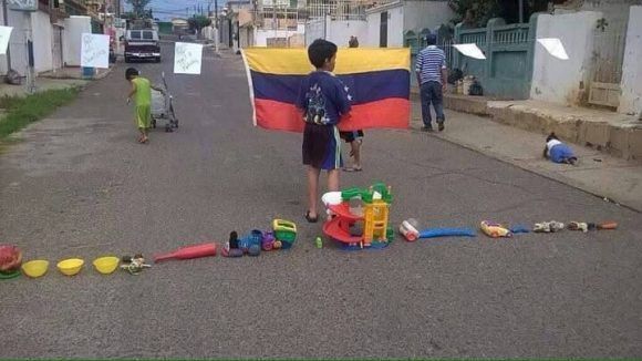 Niño jugando a trancar una calle. Foto: Twitter