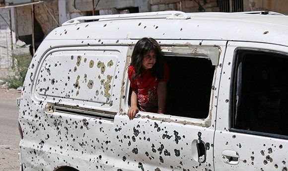 Una niña mira desde una furgoneta tiroteada en la ciudad de Deraa, en el sur de Siria. Foto: Reuters.