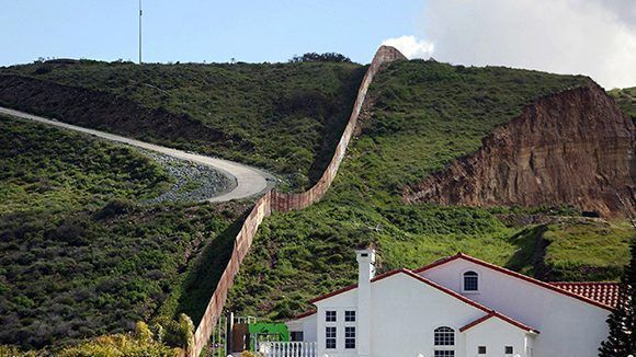 Una casa junto a una sección de la valla fronteriza que separa México de EE.UU., Tijuana (México), el 28 de febrero de 2017. Edgard Garrido/ Reuters.