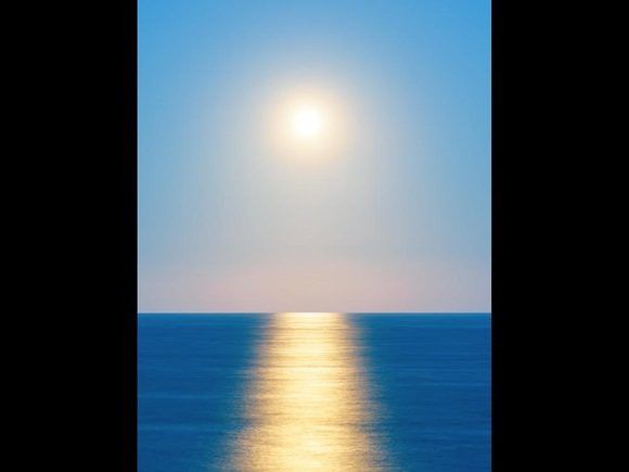 Una foto inesperada de la Luna que se levanta sobre el reluciente océano de la costa de Wairarapa, que la hacen tener una semejanza notable con el sol.