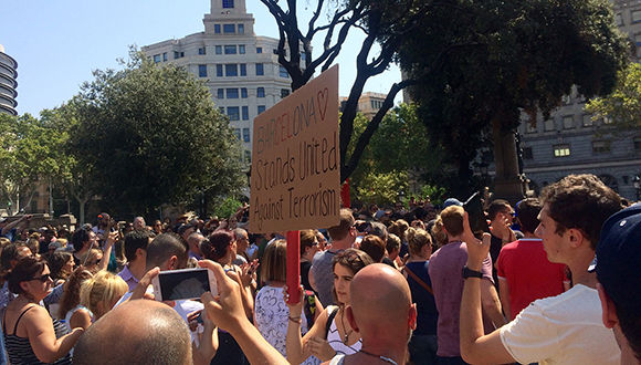 na chica sostiene una pancarta en el acto de solidaridad con las víctimas en plaza Catalunya. Foto: Elena Parreño/ Público.