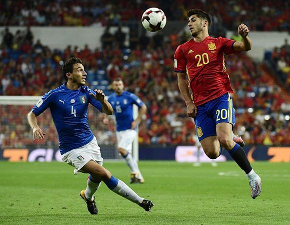 El español Marco Asensio controla el balón ante el centrocampista italiano Matteo Darmian. Foto: AFP.