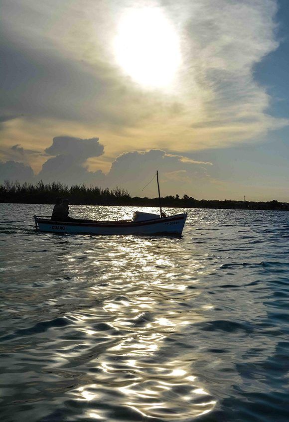 Embarcación a su paso por la playa La Boca, al atardecer, en el municipio norteño de Puerto Padre, en Las Tunas, Cuba. Foto: ACN/ Yaciel Peña.