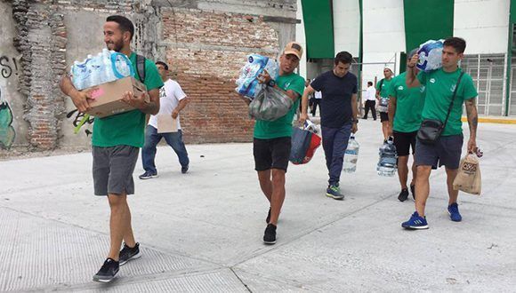 Los jugadores de Zacatepec ayudan a remover escombros. Foto: A. González / El País