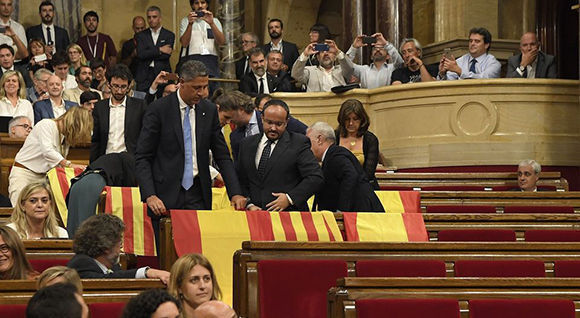 Mientras dejaban el Parlamento catalán, antes de la votación de la ley de referendo, diputados del Partido Popular desplegaron banderas de España el miércoles 7 de setiembre del 2017. Foto: AFP.
