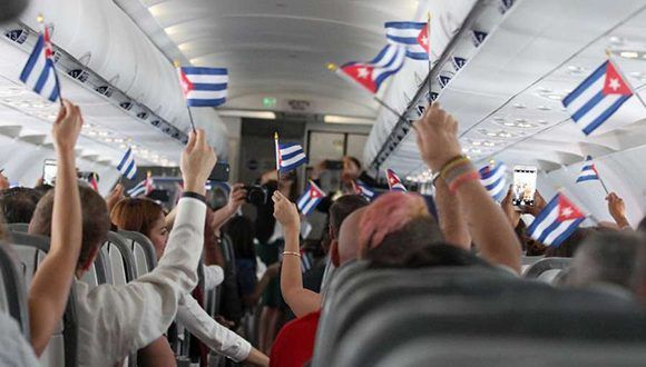 Poco después de despegar desde Fort Lauderdale, clientes ondean banderas cubanas mientras abordan el vuelo inaugural de JetBlue a Cuba. Foto: Donald Traill / AP