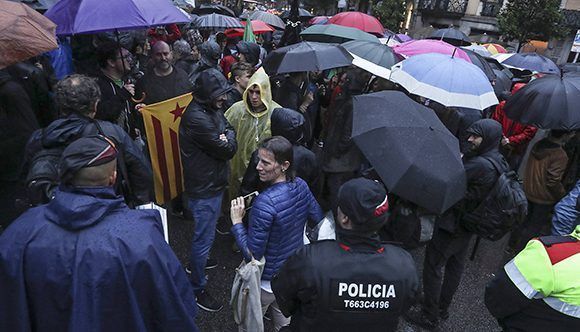 Bajo lluvia, los catalanes siguen manifestándose. En la imagen, Concentración de la CUP ante la Delegación del Gobierno para protestar contra el encarcelamiento de los presidentes de ANC y Òmnium. Foto: Joán Sánchez/ El País. 