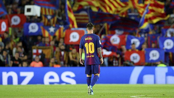 Lionel Messi, en el estadio Camp Nou, mientras hinchas del Barcelona agitan banderas a favor de la independencia catalana durante un partido ante el Eibar, el 19 de septiembre de 2017. Foto: Albert Gea / Reuters.
