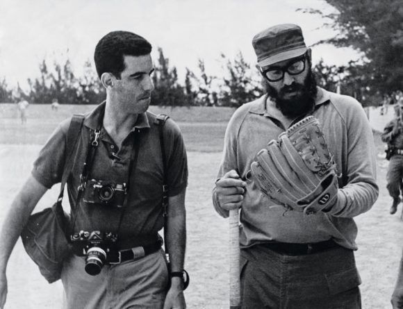 Fidel se prueba un guante en un terreno de béisbol. A su lado el fotógrafo estadounidense Lee Lockwood. 
