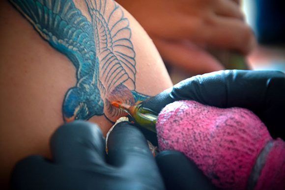 Sesión de tatuado durante la segunda edición del proyecto de arte corporal Tatuarte. Foto: Juan Pablo Carreras/ ACN.