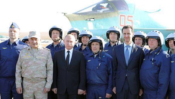 Putin y Assad posan con militares en la base aérea de Hmeimim, en Siria. Foto: Reuters.