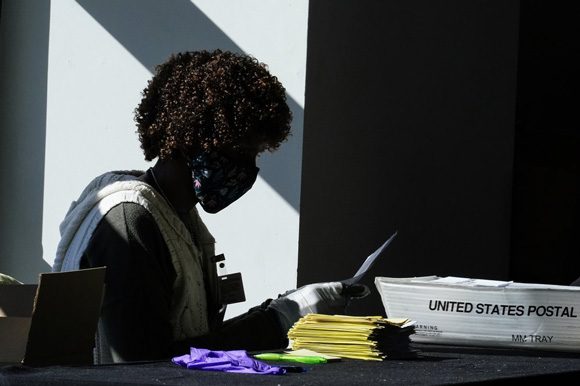 Un trabajador electoral maneja las boletas mientras continúa el conteo de votos en las elecciones el 4 de noviembre de 2020 en Atlanta, Georgia. Foto: Brynn Anderson/ AP.
