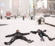 Dos personas juegan en la nieve en Times Square. Foto: John Minchillo / AP