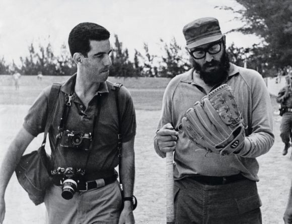 Fidel se prueba un guante en un terreno de béisbol. A su lado el fotógrafo estadounidense Lee Lockwood. Foto: Archivo.