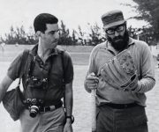 Fidel se prueba un guante en un terreno de béisbol. A su lado el fotógrafo estadounidense Lee Lockwood. Foto: Archivo.