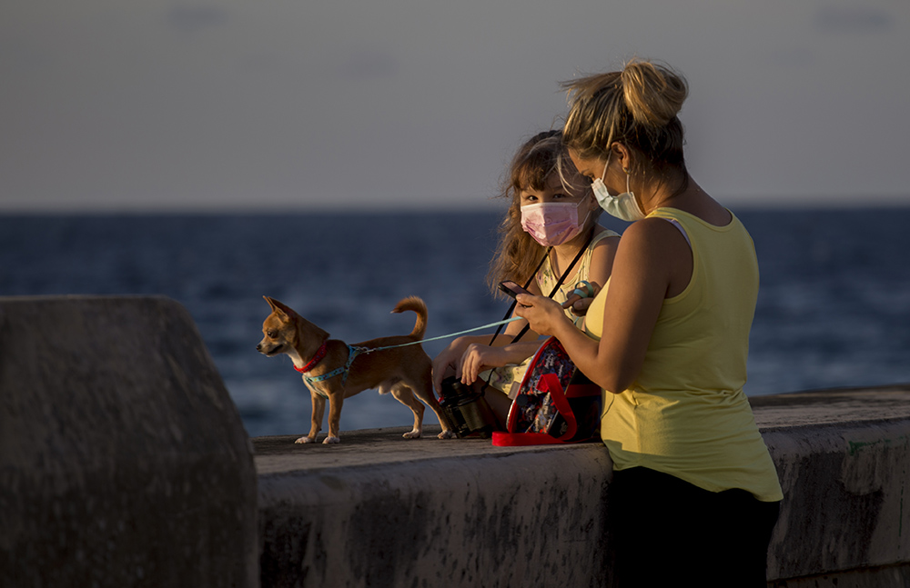 Madre, hija y mascota, en el malecón habanero. Foto: Ismael Francisco/ Cubadebate.