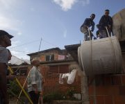 Trabajadores de la Mipyme Mambí de la Guinera suben el tanque de agua que se le otorgó a Omar Iván Rodríguez Medina, vecino de Cuba Libre, Pinar del Río. Foto: Ismael Francisco/ Cubadebate.